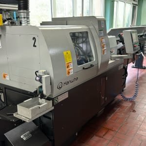 Torno tipo suizo CNC con transportador de viruta HANWHA XE 20H