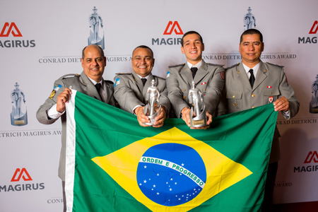 Bomberos de Brasil posando con su bandera nacional y el Premio Conrad Dietrich Magirus