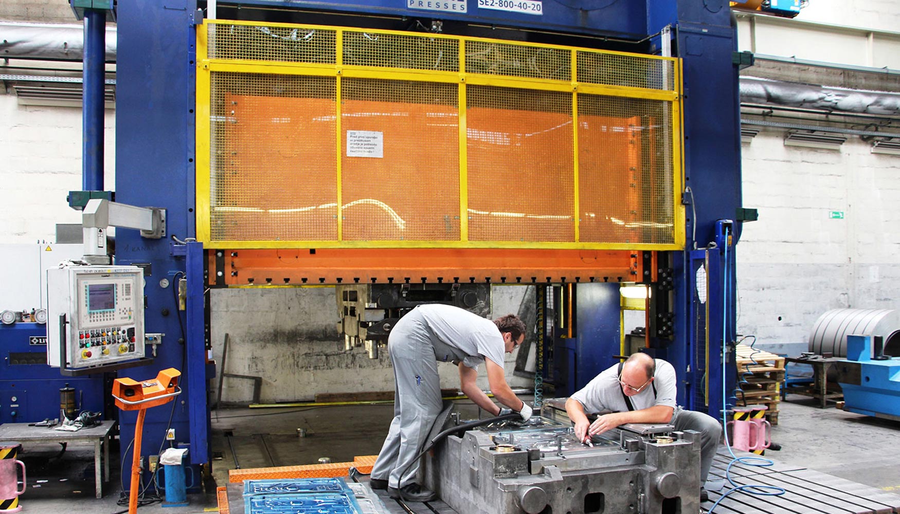 Trabajadores experimentados de Gorenje instalan sensores en los componentes de herramienta de una prensa que se utiliza para producir piezas de...