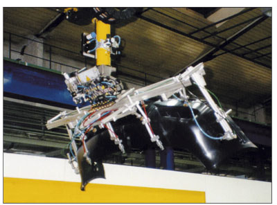 Un robot lineal Unirob R 40 de Battenfeld (carga nominal hasta 40 kg incluidas pinzas) extrae los pesados parachoques del molde, en una mquina de 27...