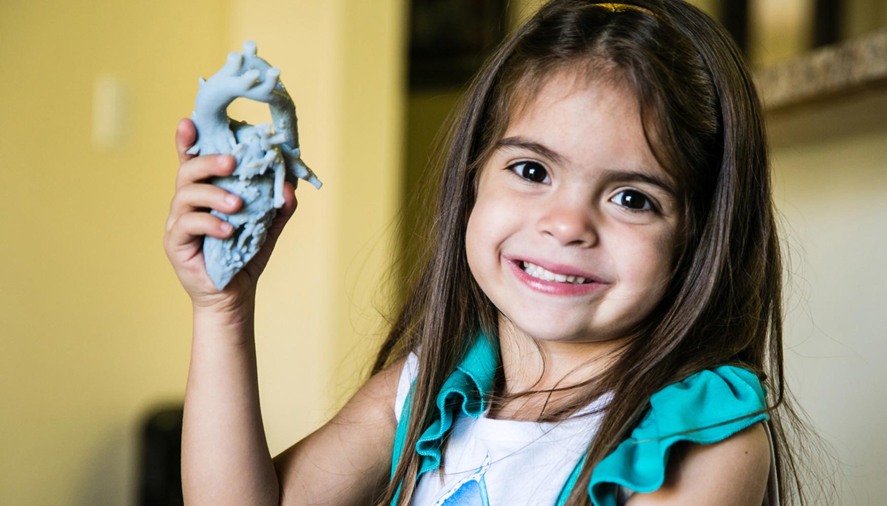 Mia Gonzlez sostiene su modelo de corazn impreso en 3D de Stratasys