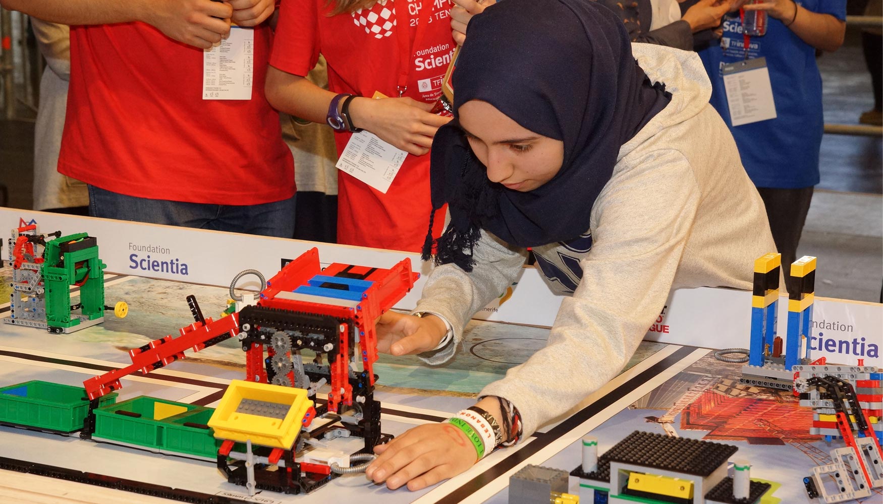 Una de los miembros del equipo jordano vencedor, GalaxyRobos, programando su robot mientras el jurado cronometra. Foto: FLL...
