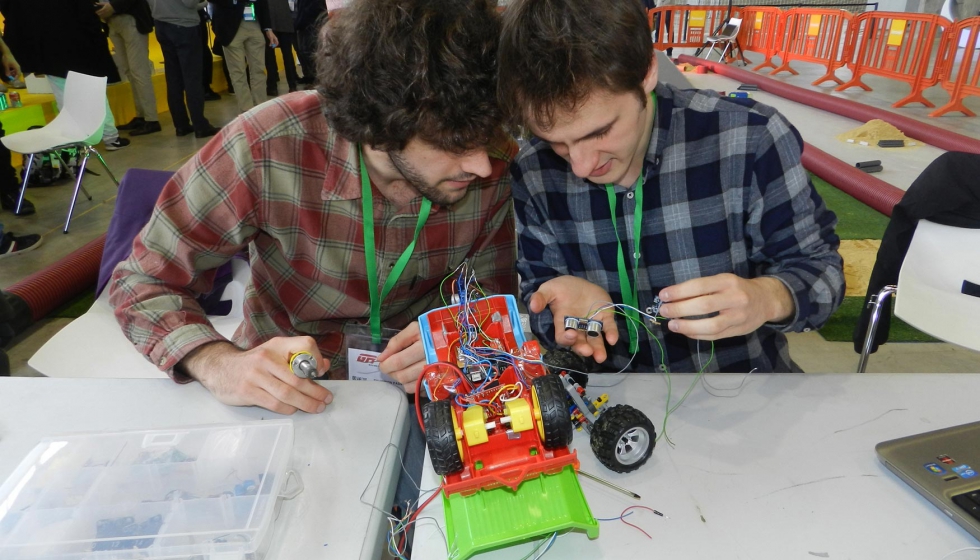 Dos chicos preparan su robot para la competicin