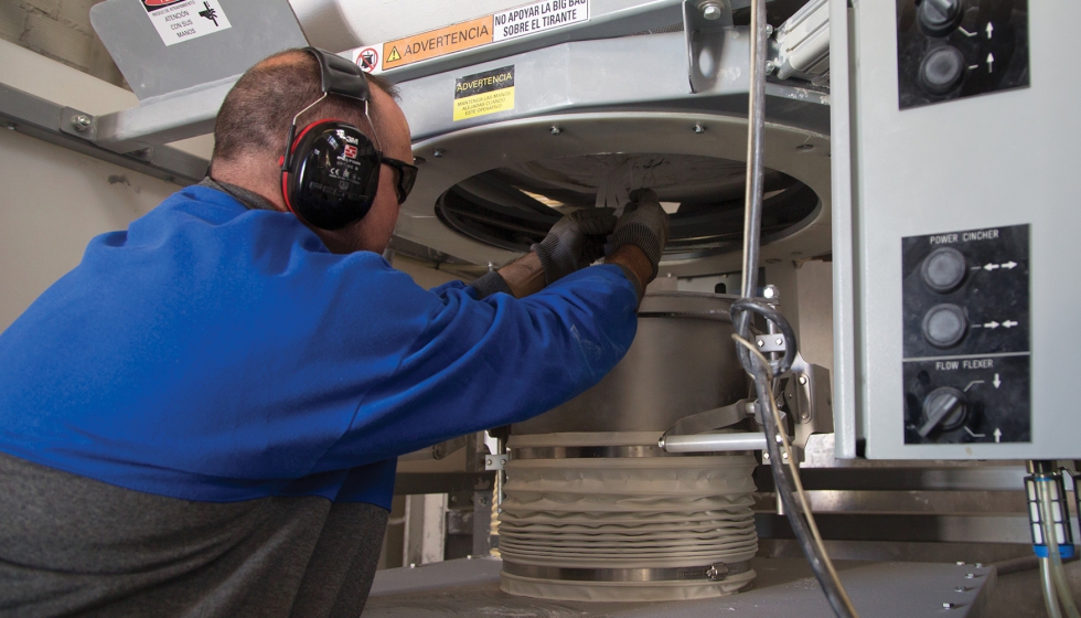 El operador tira de la manga de descarga del big bag a trav�s de la v�lvula de diafragma Power Cincher...