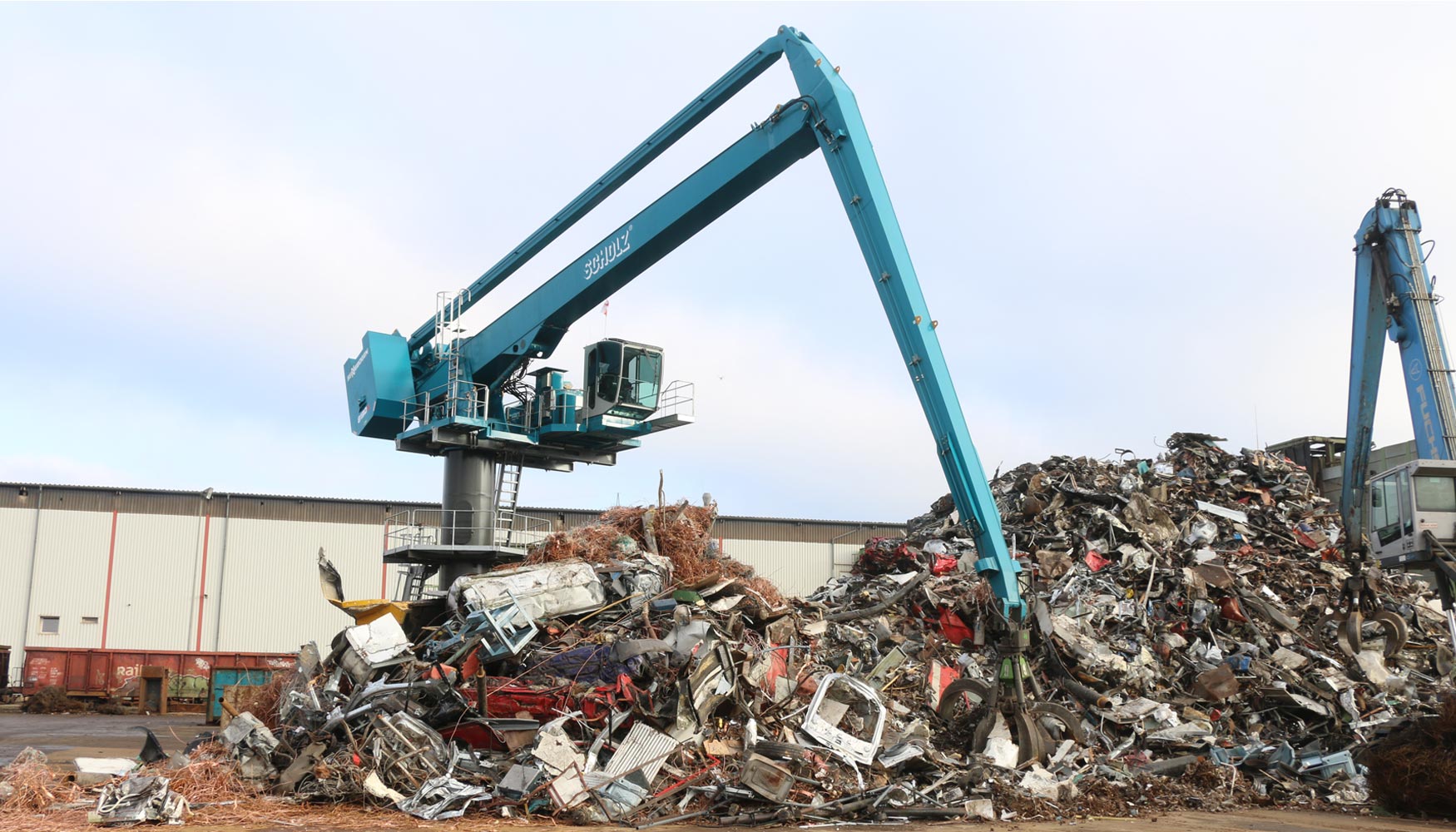 Posicionada centralmente, la Sennebogen 8130 EQ carga la trituradora de 3.000 CV en la sede de la empresa Scholz Recycling en Espenhain...