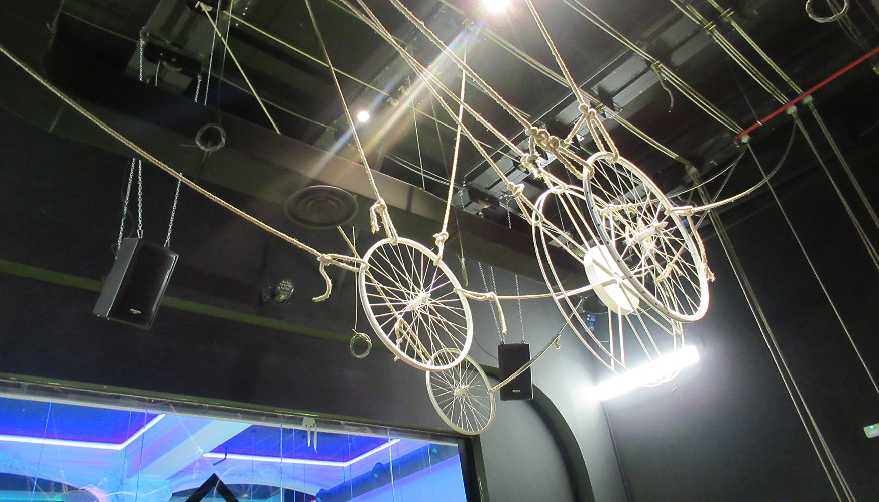 Un sistema decorativo de ruedas y poleas cuelga del techo y potencian el aspecto teatral del gimnasio