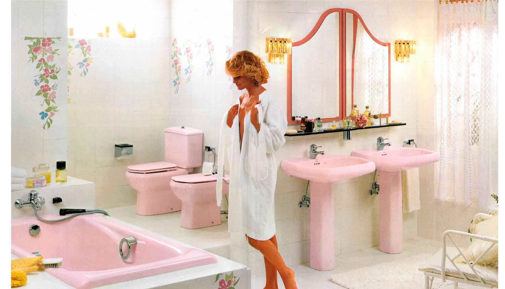 Un baño con inodoro con ducha y lavabo del mismo color que aparece en la  pared junto al espejo