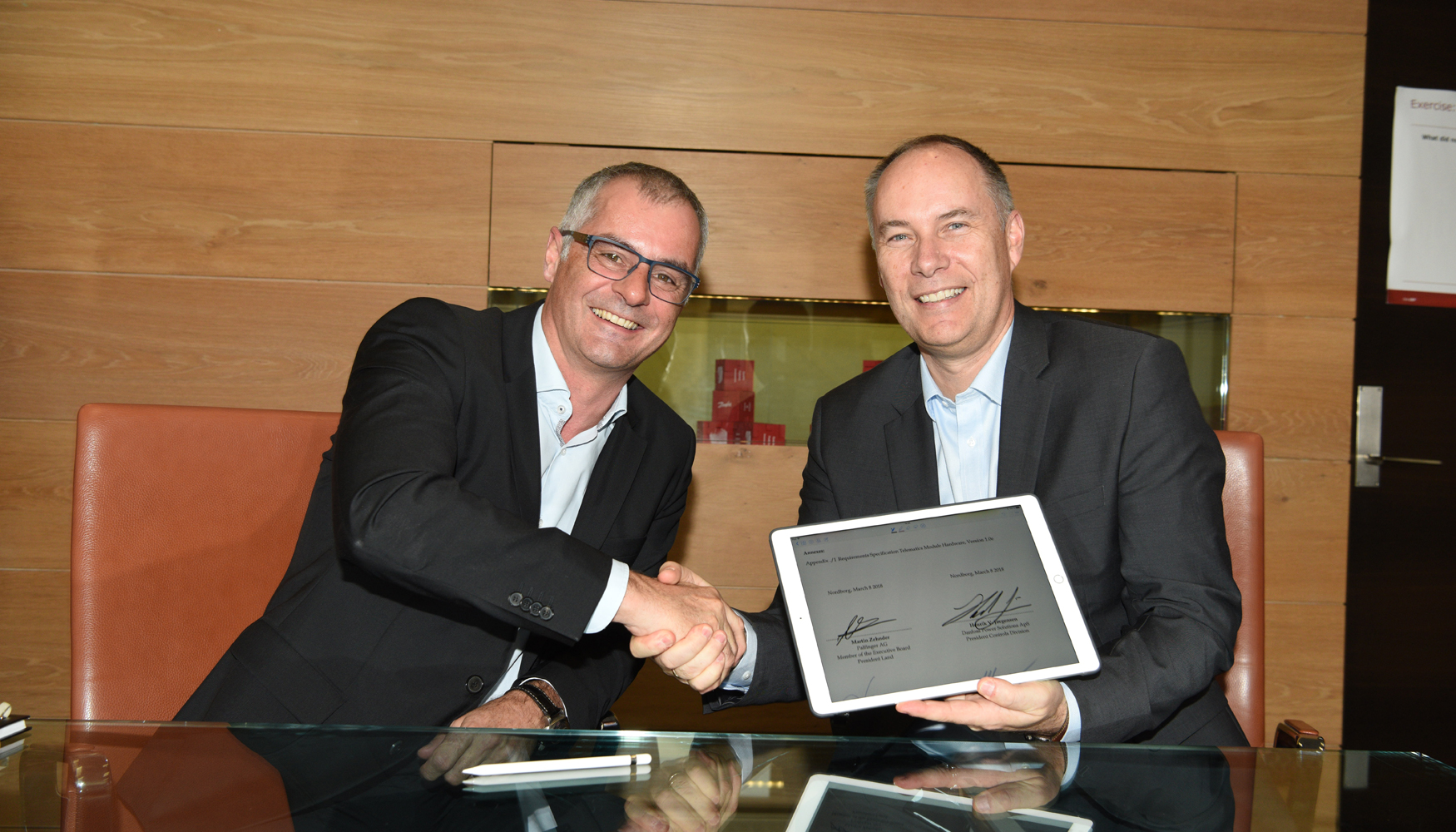Firma del acuerdo por parte de Martin Zehnder, presidente de Palfinger Land AG, y Henrik V...