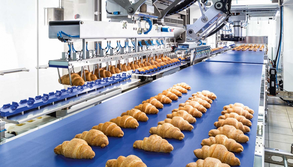 Los croissants rellenos son recogidos por un robot F2 del Transmodul y descargados en tres filas sobre la cinta