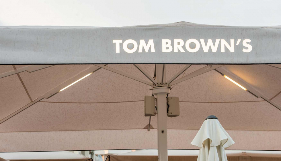 El restaurante Tom Brown's, en Calvi, cuenta con un parasol Azores con faldn luminiscente con el nombre del restaurante...