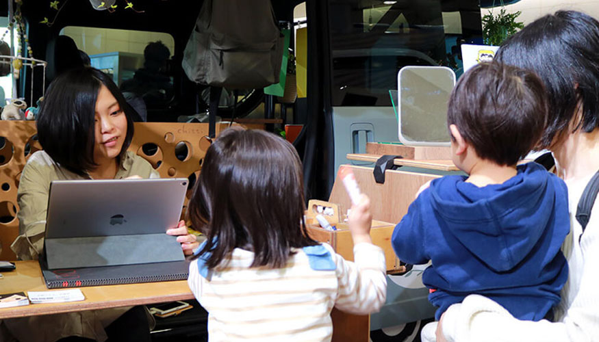 La ilustradora Chihiro (izquierda) charla con los visitantes mientras dibuja sus autorretratos