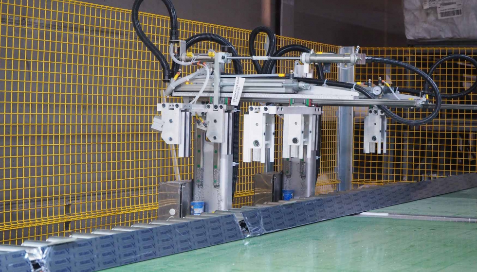 Sistema robotizado de pinzas que recoge y traslada el perfil a la cinta de la mesa de salida
