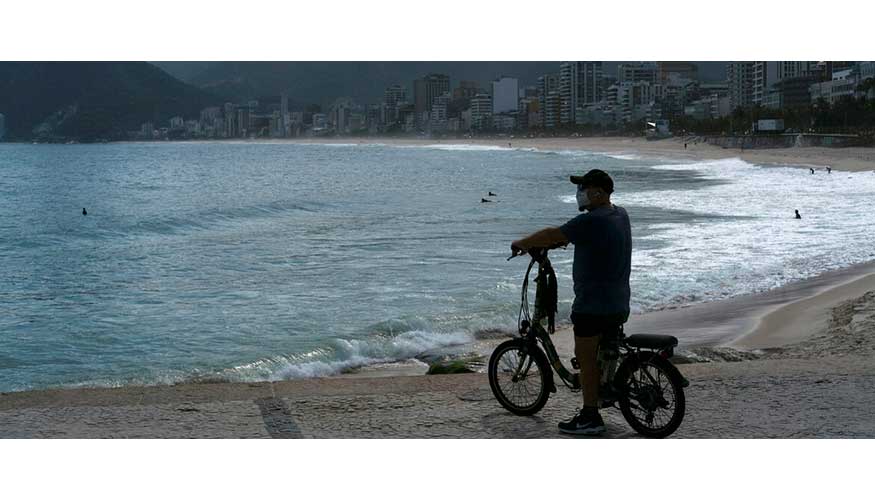 Un hombre con una mascarilla observa la playa de Arpoador durante el brote de la enfermedad del coronavirus en Ro de Janeiro, Brasil...