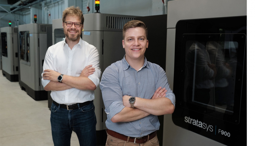 Los cofundadores de AM Craft Jānis Jātnieks (derecha) y Didzis Dejus frente a las cuatro impresoras 3D Stratasys F900 de produccin a gran...