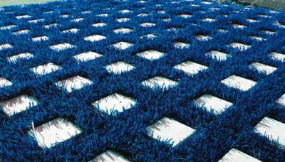 Coating formed by a mantle of perforated synthetic grass to fit into a modular stone structure
