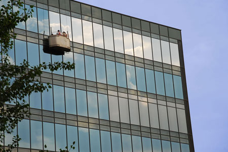 Imagen 1: Fachada de un edificio en el que se est instalando lmina Sentinel Silver 20 OSW de DTI (fila superior de cristales)...