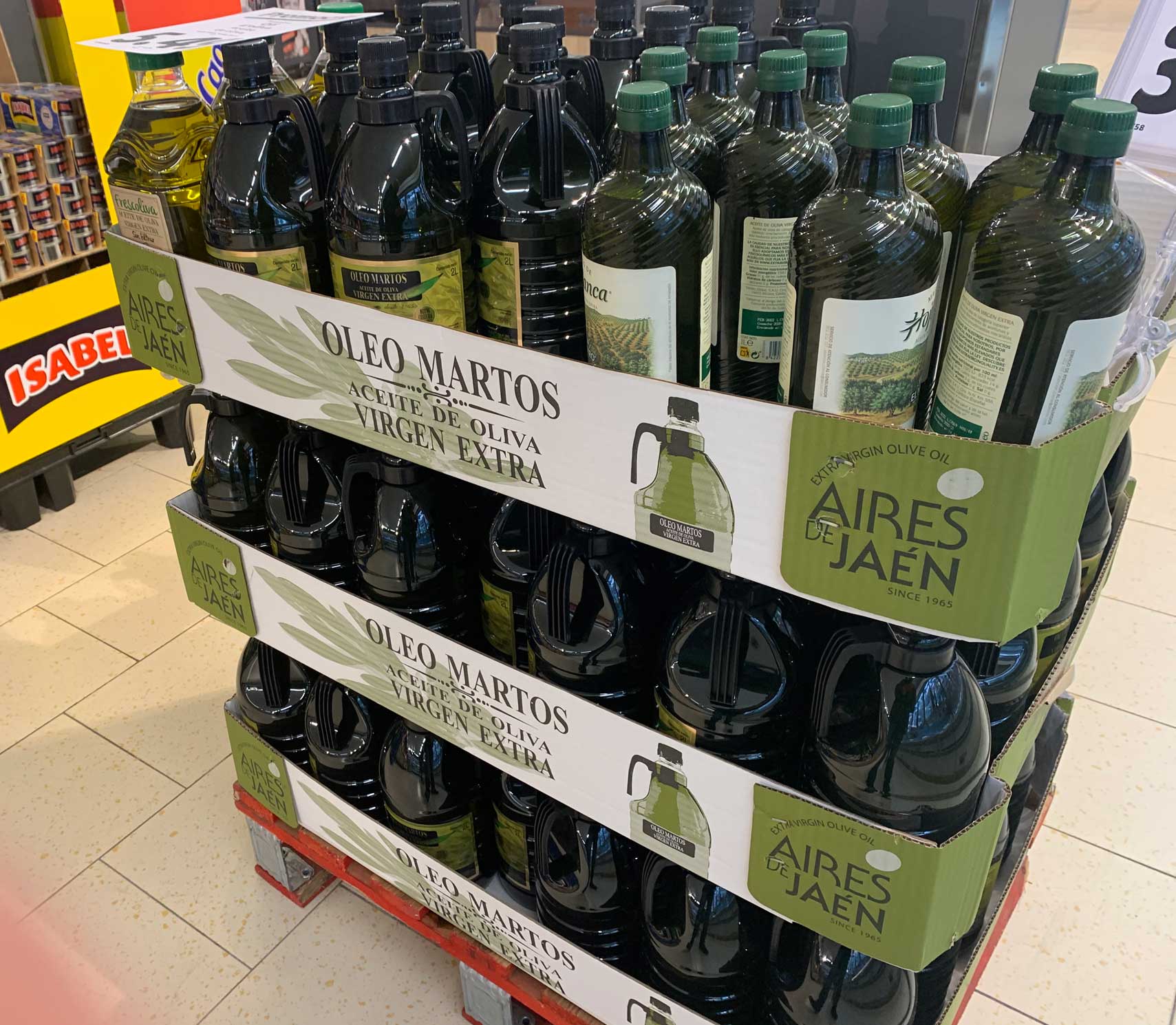 Garrafas de aceite de oliva virgen en plstico tintado expuestos en un supermercado