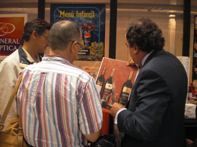 Manuel Aylln con unos clientes, mostrando los distintos soportes de impresin sobre los cuales puede imprimir la Oc Arizona...