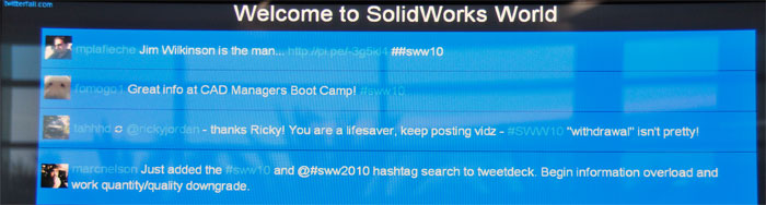 Una pantalla cerca de la zona WiFi de SolidWorks World 2010 muestra los 'tweets' relacionados con #SWW10, utilizando twitterfall...