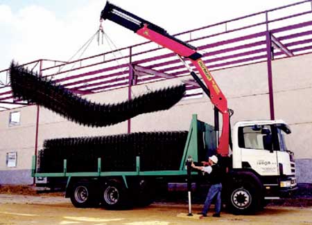 An operator loading material onto a truck with a crane Mycsa