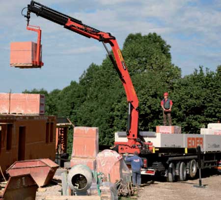 Two operators load building materials using a crane Mycsa