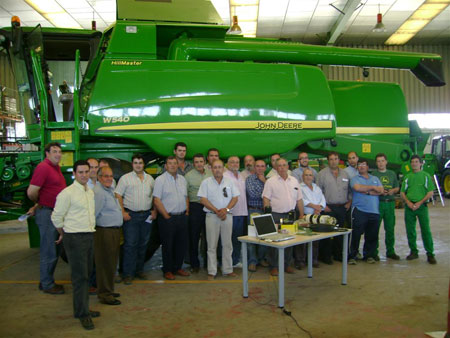 All attendees posed before the W650H John Deere Harvester