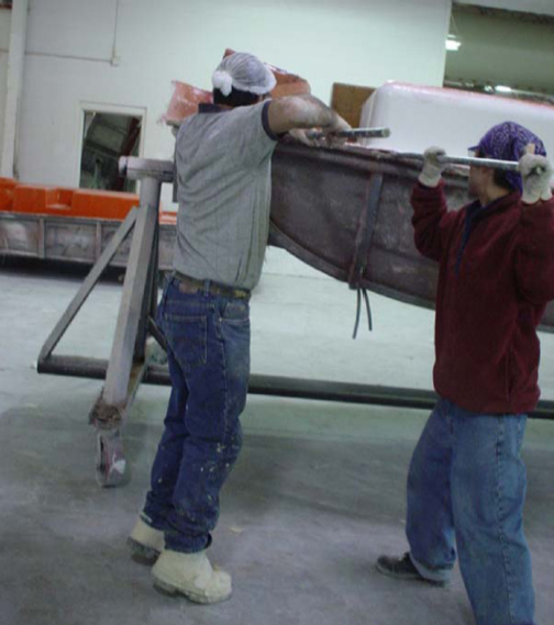 Una pareja de obreros desmoldean una pieza de FRP intentando no provocar grietas indeseadas