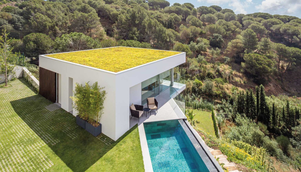 Todas las estancias de la casa se orientan hacia el entorno natural que configura una alfombra verde ante el mar que asoma a lo lejos...
