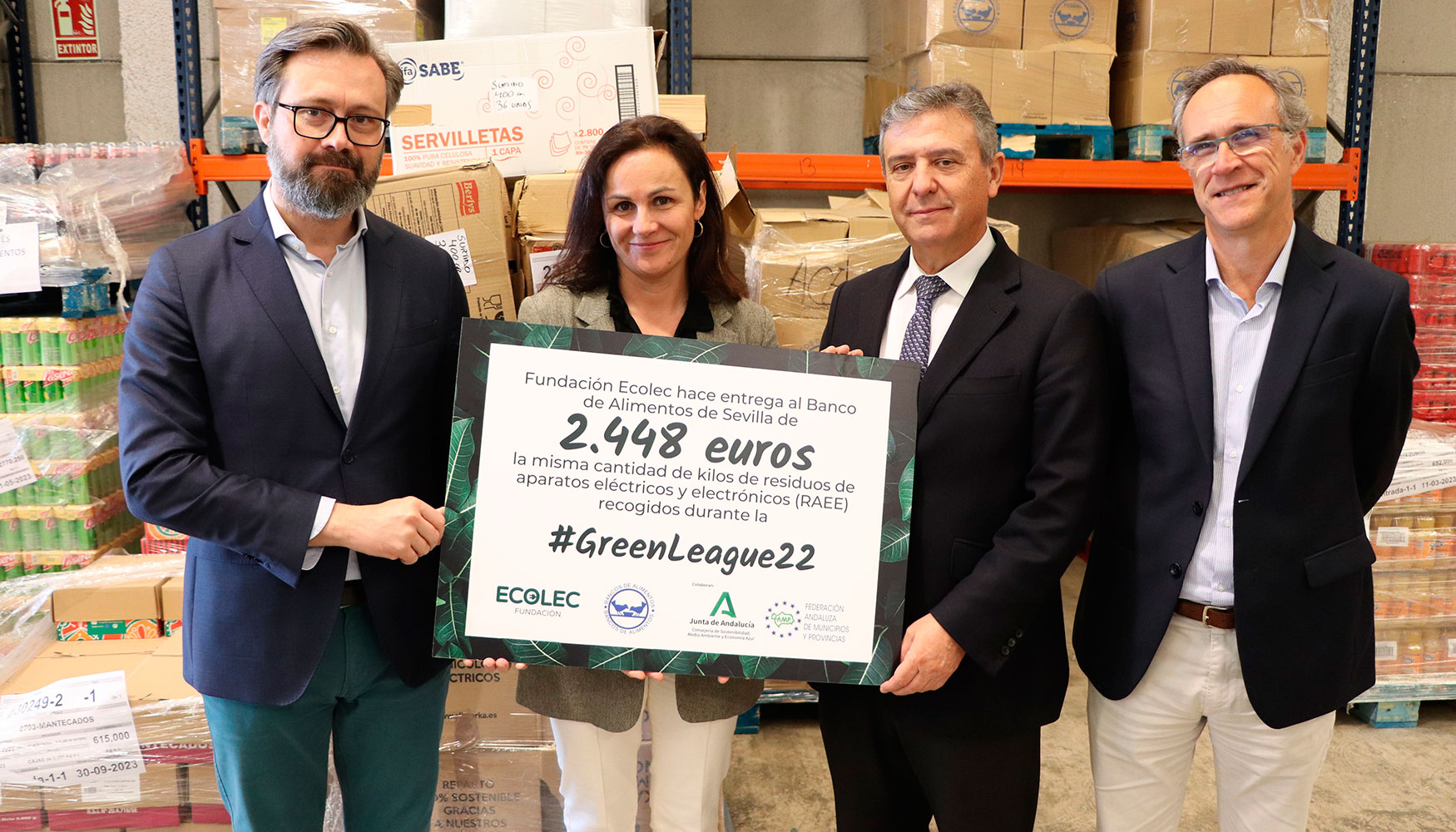 Momento de la entrega del cheque por valor de 2.448 euros en las instalaciones del Banco de Alimentos de Sevilla