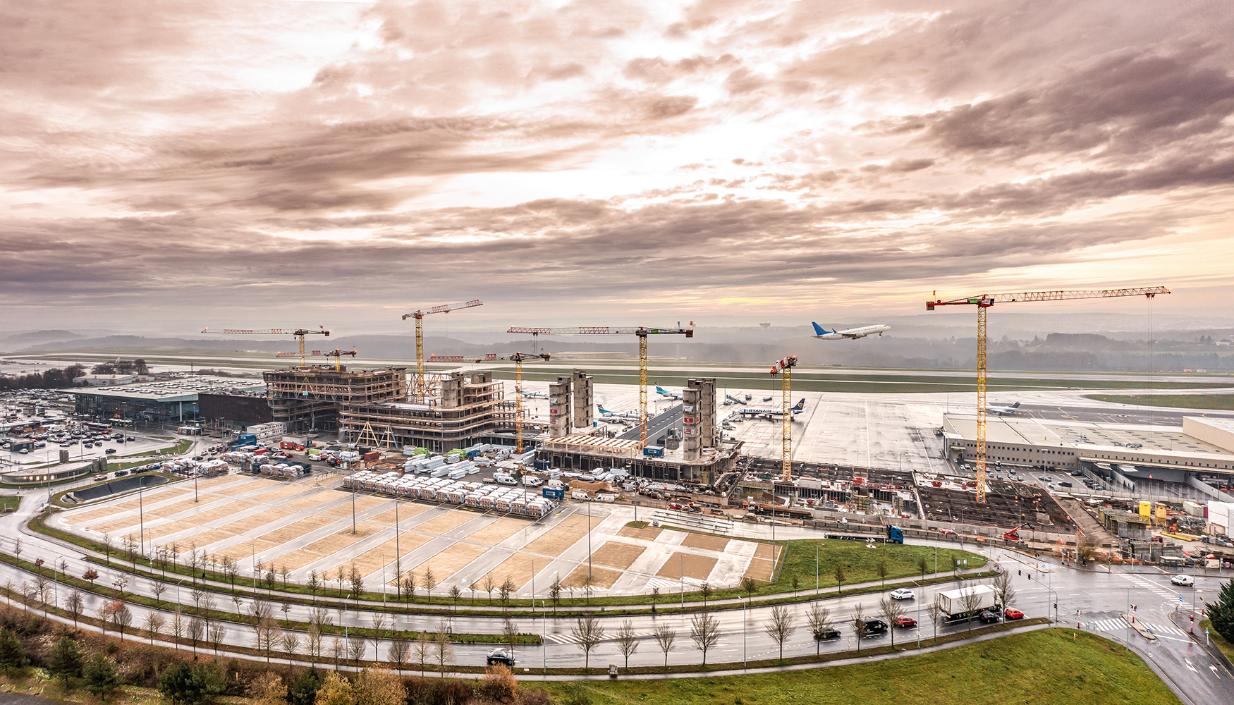 Siete gras Flat Top de Liebherr apoyan la construccin de un edificio de oficinas pegado a la pista del aeropuerto de Luxemburgo...