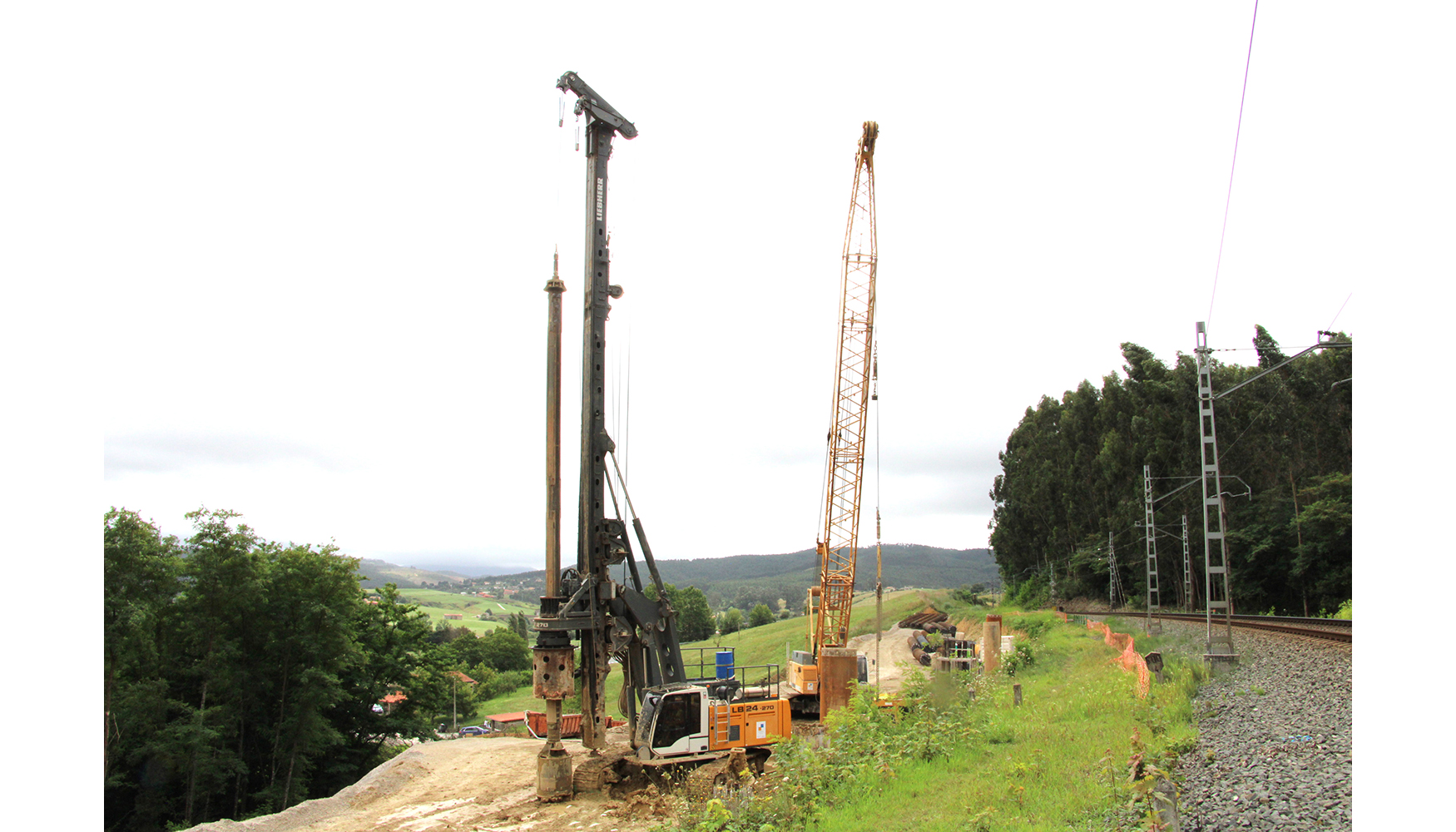 Uma mquina de estacas rotativas Liebherr LB 24-270 e uma grua de lagartas Liebherr HS 845 HD da Mota-Engil esto a trabalhar em vrios troos de via...