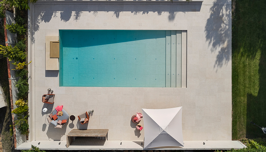 Vista cenital de la zona de piscina, donde se aprecian las jardineras que rodean el muro perimetral, para salvar este espacio exterior a dos niveles...