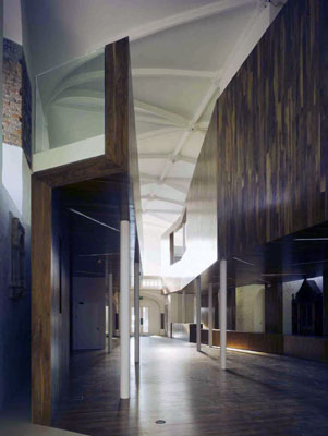 La madera cubre la nave de la iglesia, desde el suelo a los laterales, formando una Z volteada y que aloja dos galeras en la parte superior...