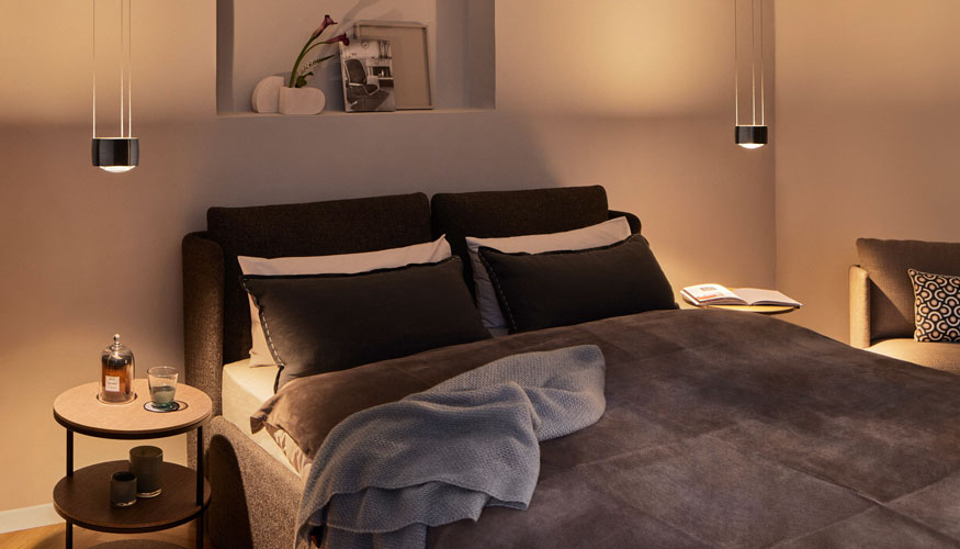 Las soluciones lumnicas de Occhio mejoran el bienestar en zonas como el dormitorio con una luz controlada que puede regularse intuitivamente...