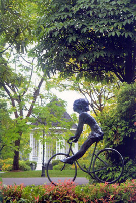 Escultura de 'Chica en Bicicleta', que se funde con el verde fondo./ National Parks Board