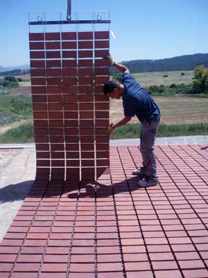 Operator placing a ceramic paving with help of a crane