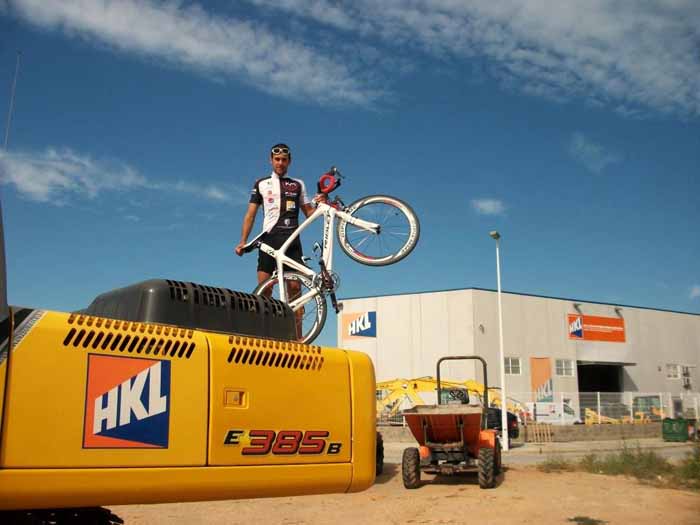 Vctor Gadea, triatleta patrocinado por HKL Valencia, sobre una excavadora New Holland perteneciente a su flota de alquiler...