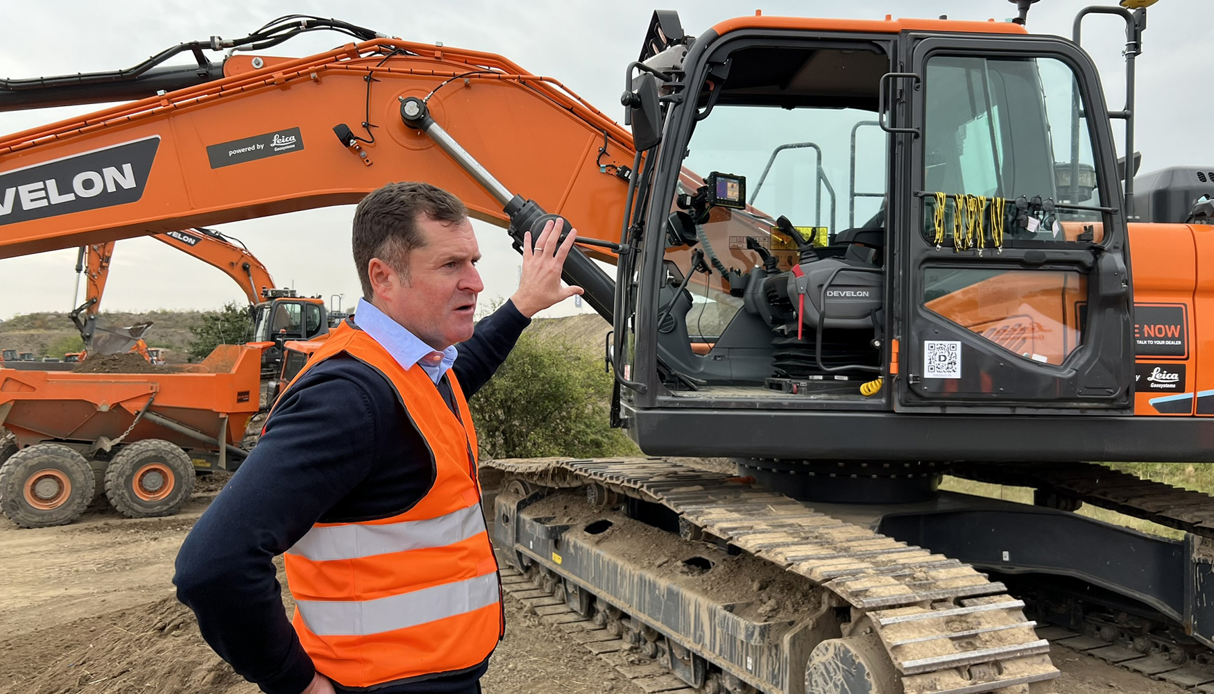 Neil Williams, presidente da Divis�o de Controlo de M�quinas da Leica Geosystems, em frente � escavadora DX225LC-7...