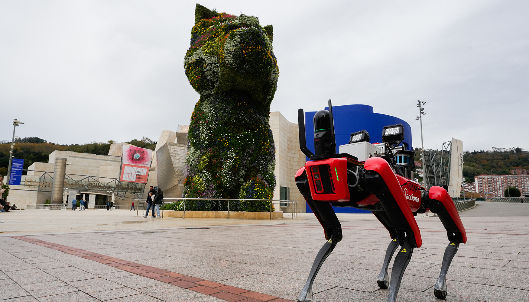 El perro-robot de Acciona posa delante de Puppy, el west highland terrier de 13 metros cubierto de flores ubicado junto al Museo Guggenheim de Bilbao...