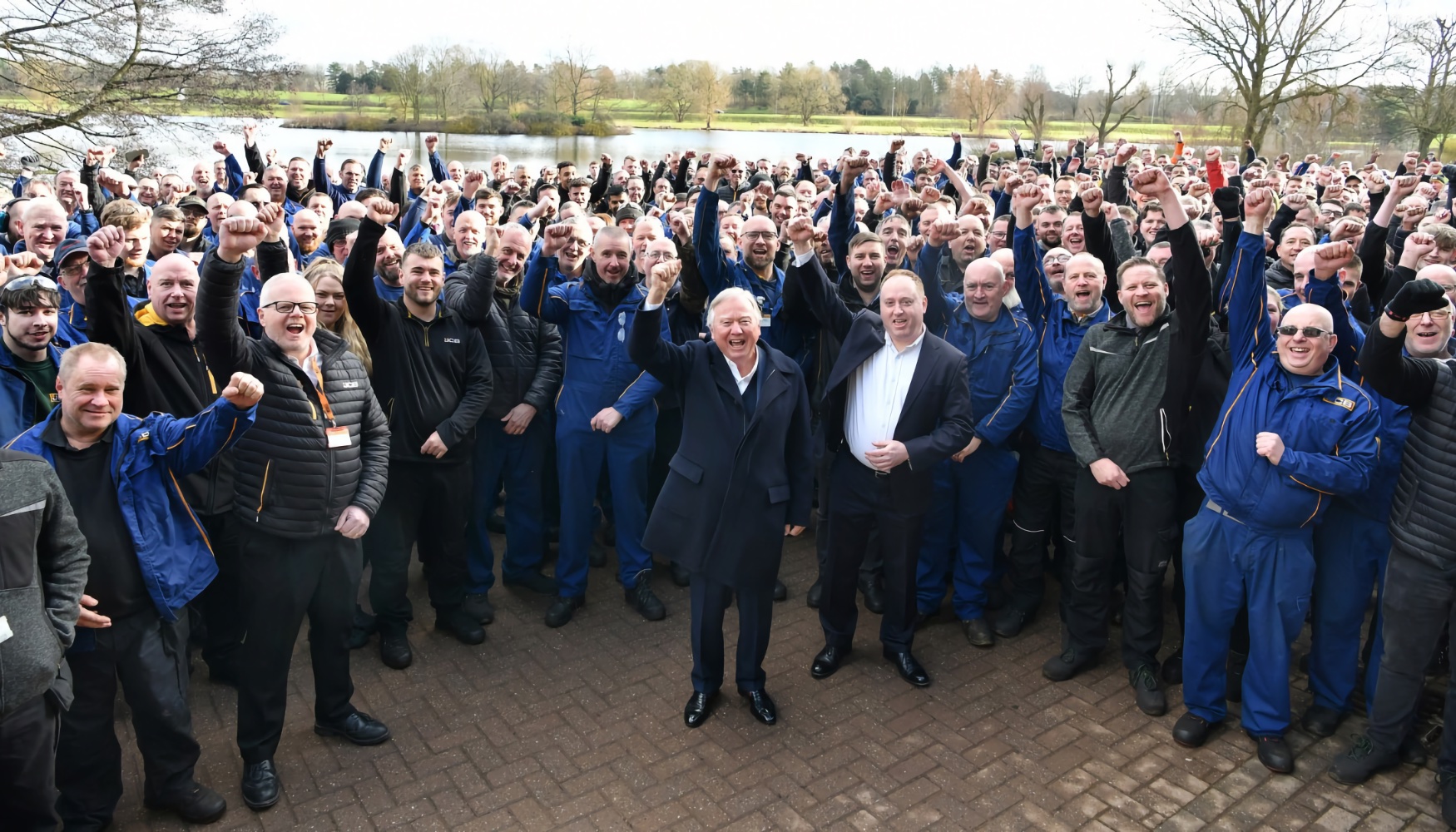 Lord Bamford rodeado de trabajadores relacionados con la icnica mquina de JCB