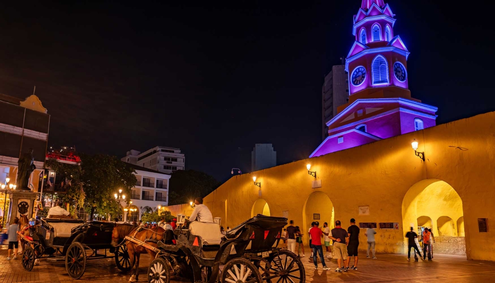 Perspectiva nocturna de la Torre del Reloj con sus tradicionales coches de caballos...