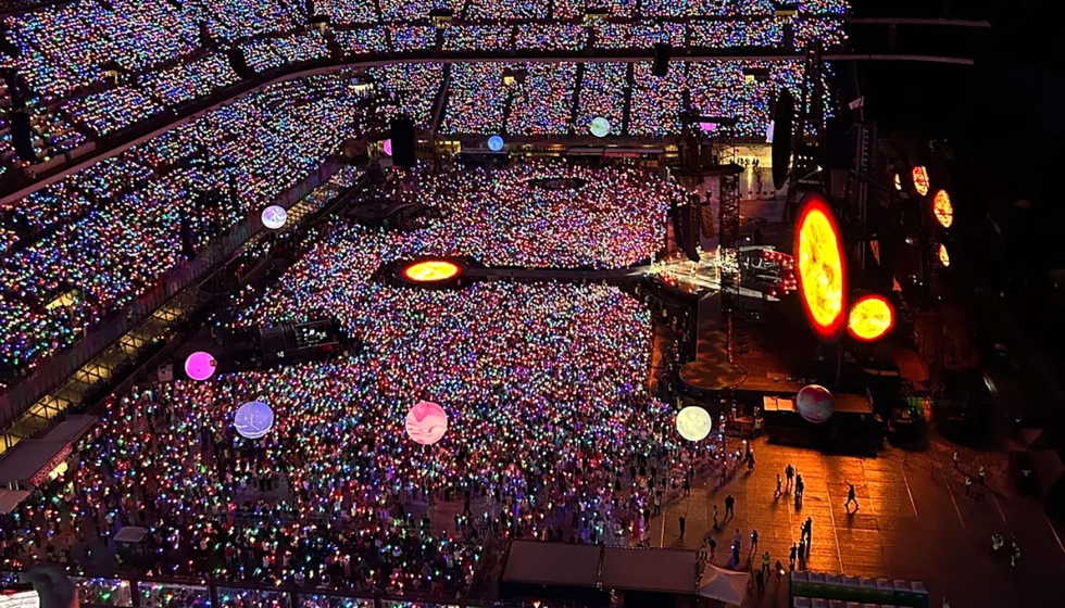 Panormica del concierto de Coldplay con el estadio iluminado por los brazaletes