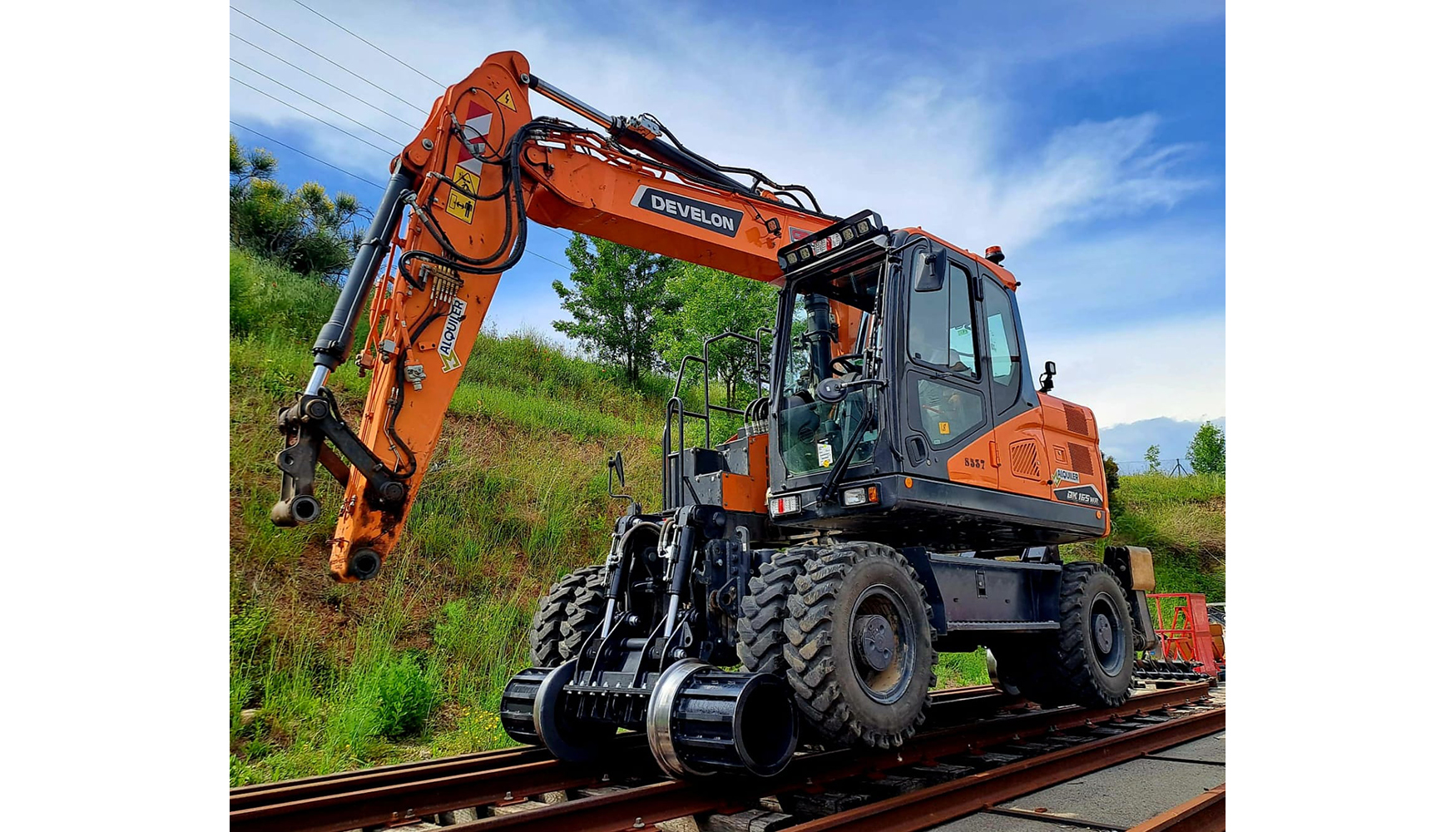 Excavadora Develon DX165WR adaptada con el sistema bivial que permite su uso sobre rales