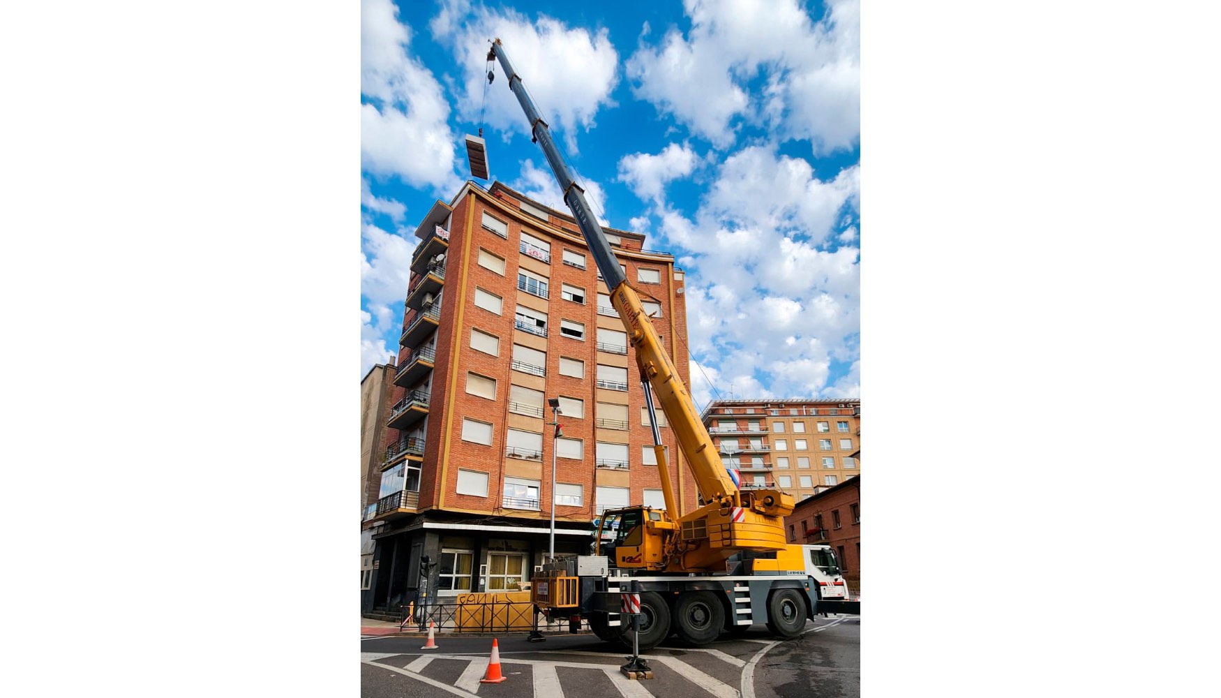 Gra mvil Liebherr LTM 1055-3.2 de Gras Garte izando material de obra hasta la cubierta de un edificio residencial en Calahorra, La Rioja...