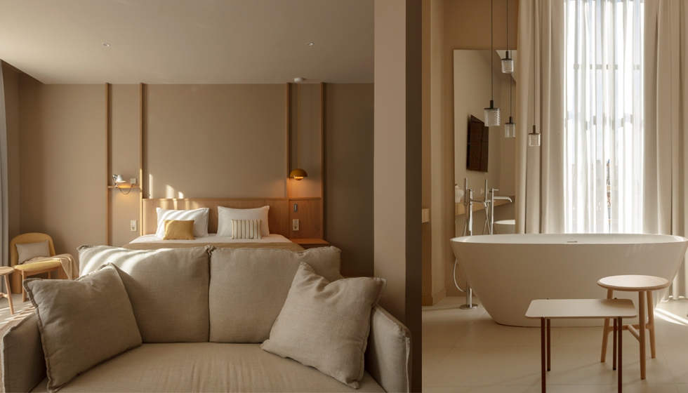 Habitacin con la cama como elemento central, cabecero que oculta el bao, escritorio multifuncional y acabados en madera de roble y tonos amarillos...