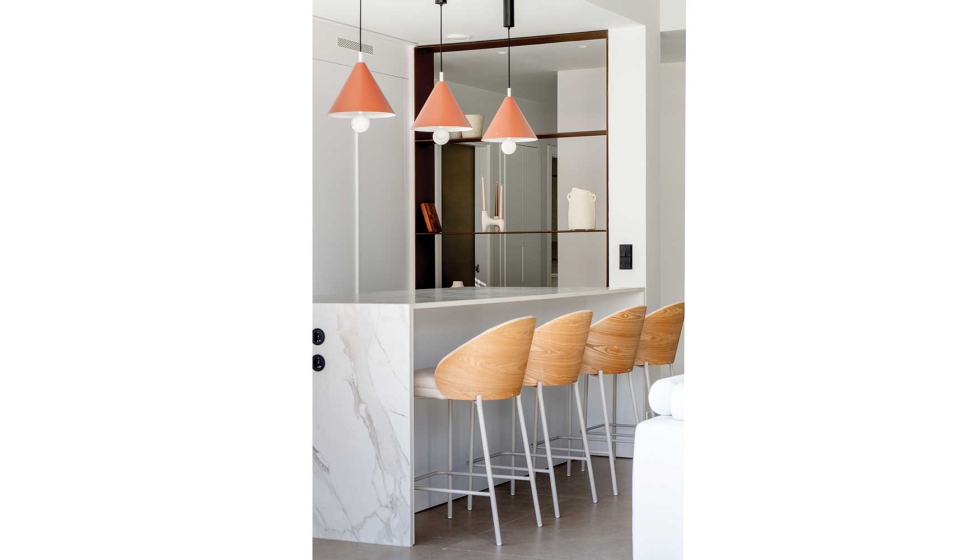 La cocina est� equipada con mobiliario blanco, incorpora una isla de piedra sinterizada con cascada y sillas altas...