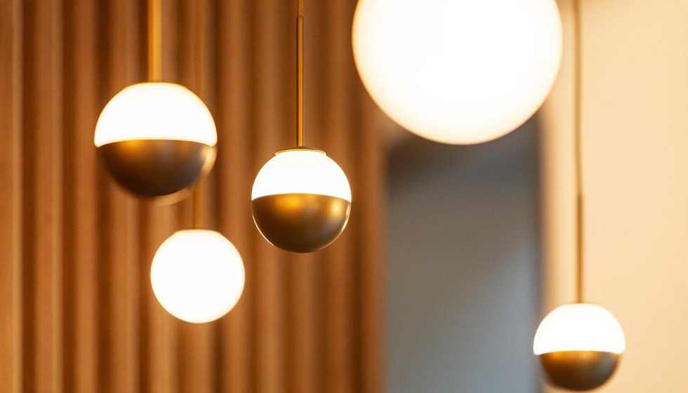 Las l�mparas se integran sobre un fondo c�lido de madera natural y tonos neutros, acompa�adas de vegetaci�n que aporta frescor...