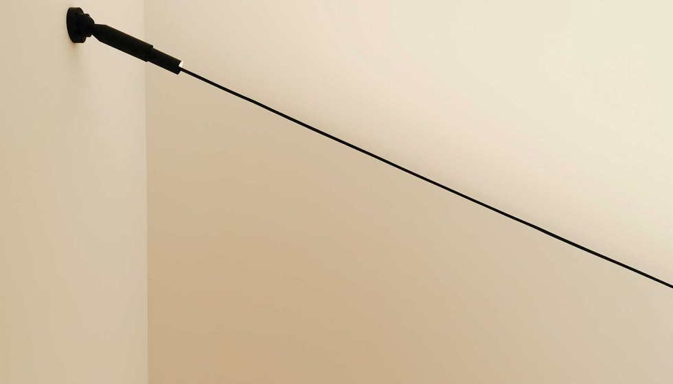 Tira LED sobre un tensor para iluminar hacia arriba sobre el hueco de una escalera. Fuente de luz invisible que rebota contra las paredes y el techo...