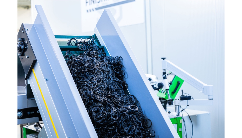 La cinta de alimentaci�n transporta las piezas reci�n moldeadas hacia el contenedor de procesamiento