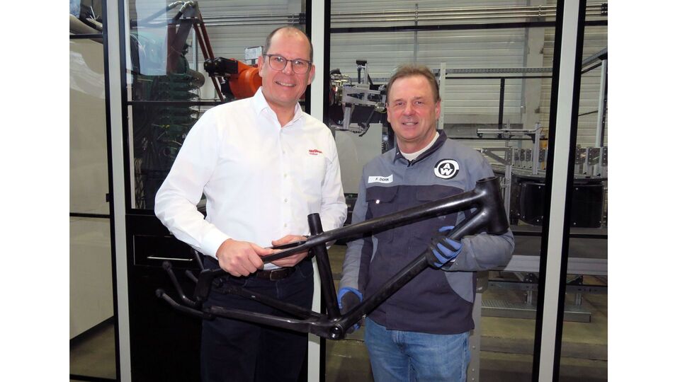 Felix Dorn, da Weber Fibertech, � direita, e Joachim Scheffer, da Oerlikon HRSflow, apresentam um quadro para a bicicleta juvenil li...